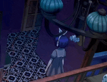 a girl in a blue dress stands on a balcony