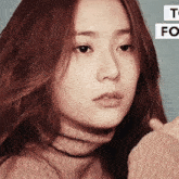 a close up of a woman 's face with a turtleneck sweater on .