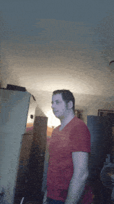 a man in a red shirt is standing in front of a refrigerator