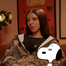a woman sitting next to a snoopy dog with the number 3 in the background