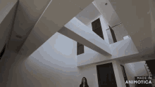 a woman stands in a room with the words made in animotica on the bottom right