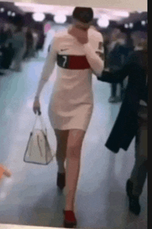 a woman in a white dress with the number 7 on the sleeve