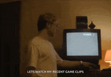 a man is standing in front of a television with the words lets watch my recent game clips below him .
