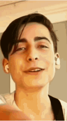 a close up of a young man 's face with his eyes closed and a smile on his face .
