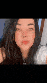 a close up of a woman taking a selfie with her eyes closed and her hair blowing in the wind .