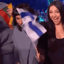 a woman is holding a small blue and white flag while standing next to another woman .