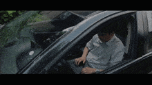 a man sits in a car using a laptop computer