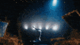 a person standing on a stage with their arms outstretched in the air