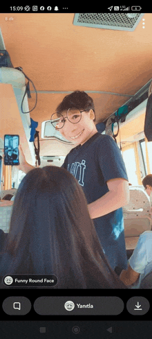 a phone screen shows a boy wearing glasses and a funny round face