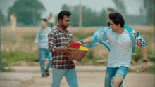 a man is holding a basket of flowers and another man is holding his arm