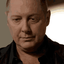 a close up of a man 's face with a black shirt