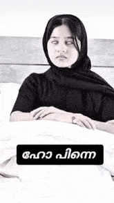 a woman wearing a black scarf and a ring is laying in bed