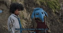 a boy and a blue elephant mascot are standing next to each other .