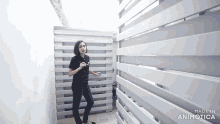 a woman in a black shirt is standing in front of a white fence made by animatica