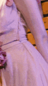 a woman in a purple dress with purple flowers on the sleeves