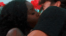 a man and a woman kissing in front of a flower pot