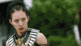 a woman with a ponytail and a sword in her hand looks at the camera