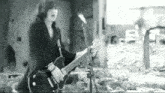 a man is playing a guitar in front of a microphone in a black and white photo