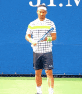 a man holding a tennis racquet in front of a sign that says u.s. open