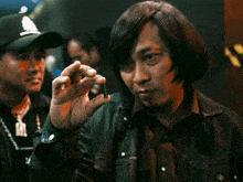 a man in a striped jacket holds a small object in his right hand
