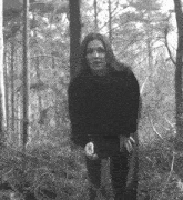 a black and white photo of a woman in a forest