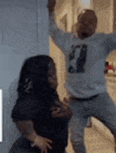 a man and a woman are standing next to each other in a room .