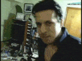 a blurry picture of a man in a room with pictures on the wall and a door