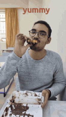 a man is eating a piece of cake with the word yummy written above him