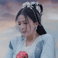 a woman in a blue and white dress is holding an apple