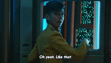 a man in a yellow jacket is standing in front of a screen that says oh yeah like that