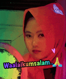 a woman wearing a pink scarf with the words waalaikumsalam