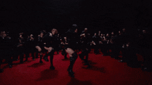 a woman in black boots is dancing on a red carpet
