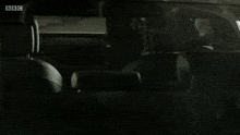 a black car with license plate by13vmx is parked in a dark garage