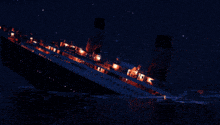 a large ship is floating in the water at night and the word titanic is on the side