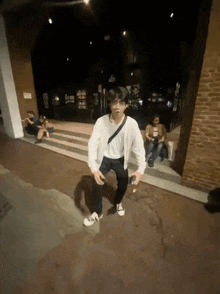 a man in a white shirt and black pants is dancing