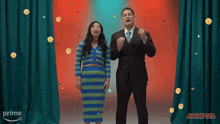 a man and a woman are standing in front of a curtain that says prime on it