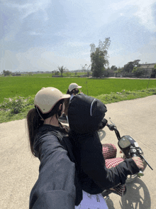 a person riding a motorcycle with a person in the back wearing a hoodie that says ' snoopy '