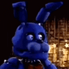 bonnie the blue bunny from five nights at freddy 's is standing in a dark room with a bow tie .