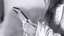a woman is holding a cell phone in her hands .