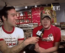 a man in a red shirt is being interviewed by another man in a white shirt