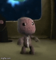 a small stuffed animal is dancing in front of a computer monitor .
