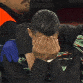 a man is praying with his eyes closed and his hands together .