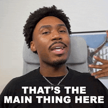 a man sitting in a chair with the words that 's the main thing here on his face