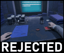 a person sitting at a desk with a bottle of pills and the word rejected
