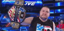 a man is holding a wrestling championship belt in front of a screen that says live .