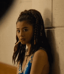 a woman with braids in her hair smoking a cigarette
