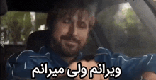 a man with a beard is sitting in a car with a foreign language written on his face .