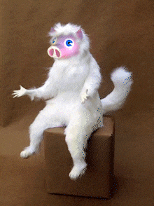 a stuffed animal with a pig face painted on its face sits on a box