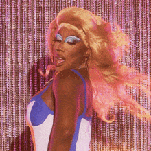 a drag queen in a blue and white top is dancing