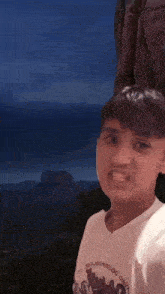 a young man wearing a white t-shirt with the word dave on it is making a funny face .